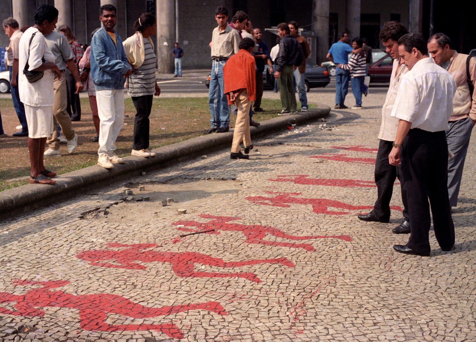 Manifestantes pintam, com tinta vermelha, corpos em frente à Igreja da Candelária, em protesto contra a chacina, em 27 de julho de 1993  — Foto: Jorge William / Agência O Globo