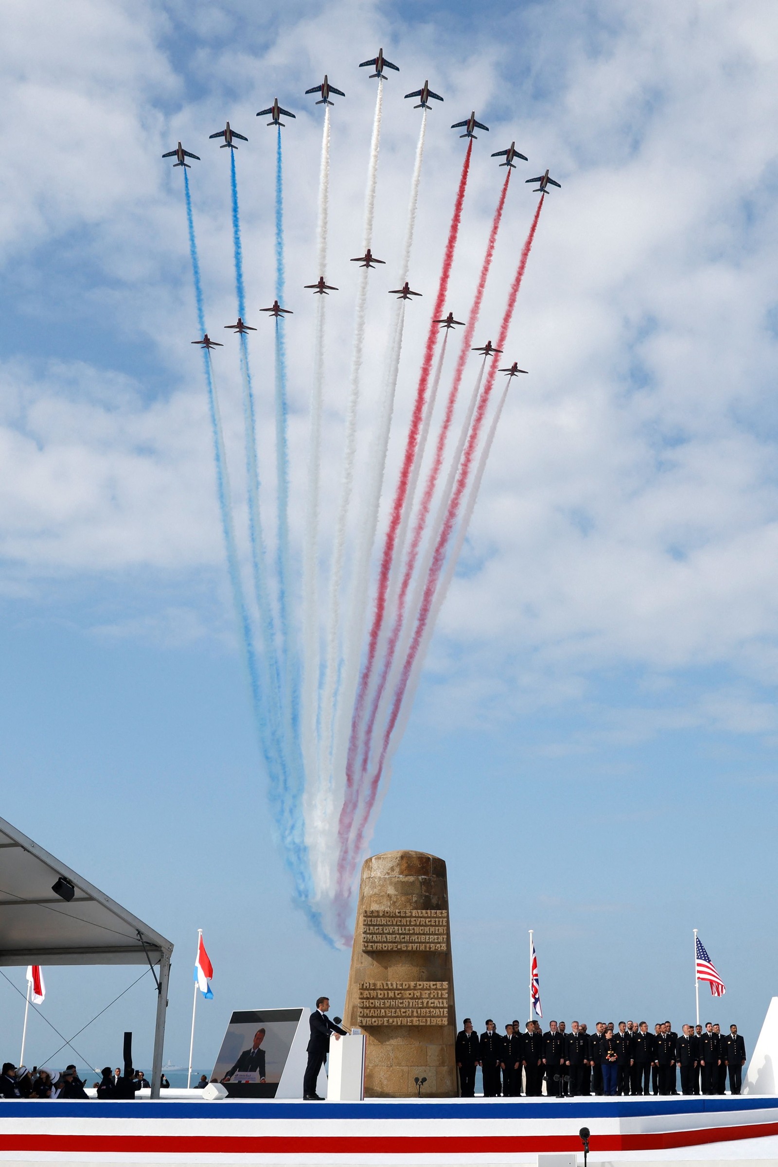 A equipe de vôo acrobático de elite da Força Aérea Francesa "Patrouille de France" (topo), seguida pela equipe acrobática da Força Aérea Real Britânica (RAF), os "Red Arrows" realizam um sobrevoo acima durante a cerimônia comemorativa internacional na Praia de Omaha marcando o 80º aniversário dos desembarques aliados do "Dia D" da Segunda Guerra Mundial na Normandia — Foto: Ludovic MARIN / AFP