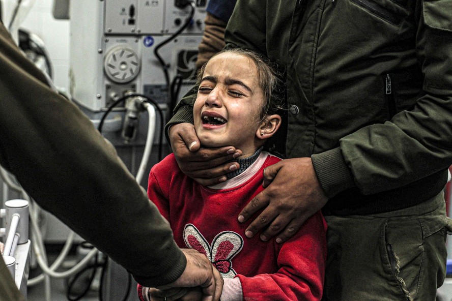 Menina chora a morte de seus parentes, que foram mortos por bombardeios israelenses, em Khan Yunis, no sul da Faixa de Gaza