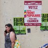 Franceses caminham em frente à cartaz eleitoral na França - EMMANUEL DUNAND / AFP