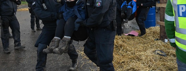 Policiais retiram ativistas anticarvão de um celeiro na vila de Luetzerath, oeste da Alemanha, antes de uma demolição para expandir uma mina de carvão nas proximidades. — Foto: INA FASSBENDER / AFP