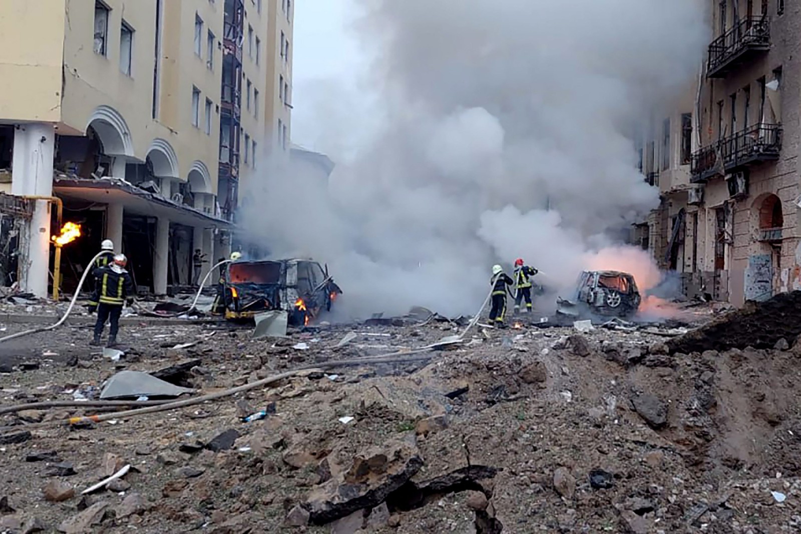 Bombeiros combatendo focos de incêndio em área atingida pelo ataque russo em Kharkiv — Foto: Handout / UKRAINIAN EMERGENCY SERVICE / AFP