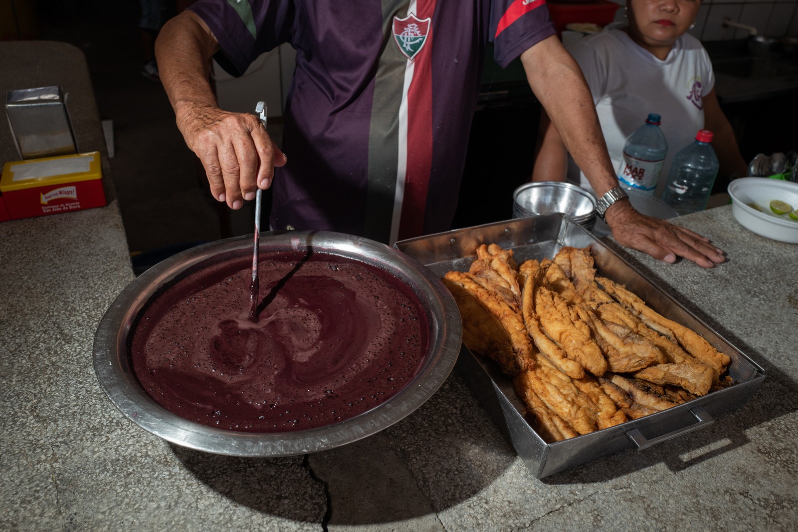 No mercado Ver-o-Peso, peixe frito é servido com açaí em sua forma aveludada e saborosa de acompanhamento, em Belém do Pará — Foto: Alessandro Falco/The New York Times