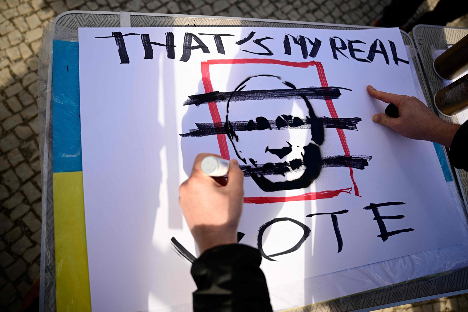 Manifestantes fazem cartazes em um comício em frente à embaixada russa em Berlim, onde eleitores fizeram fila para votar nas eleições presidenciais russas de 17 de março de 2024. — Foto: Tobias SCHWARZ / AFP
