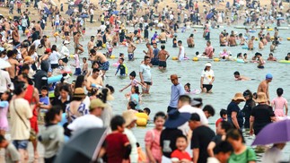 Pessoas se refrescam em uma praia em meio ao clima quente em Qingdao, na província de Shandong, no leste da China.  — Foto: AFP / China OUT