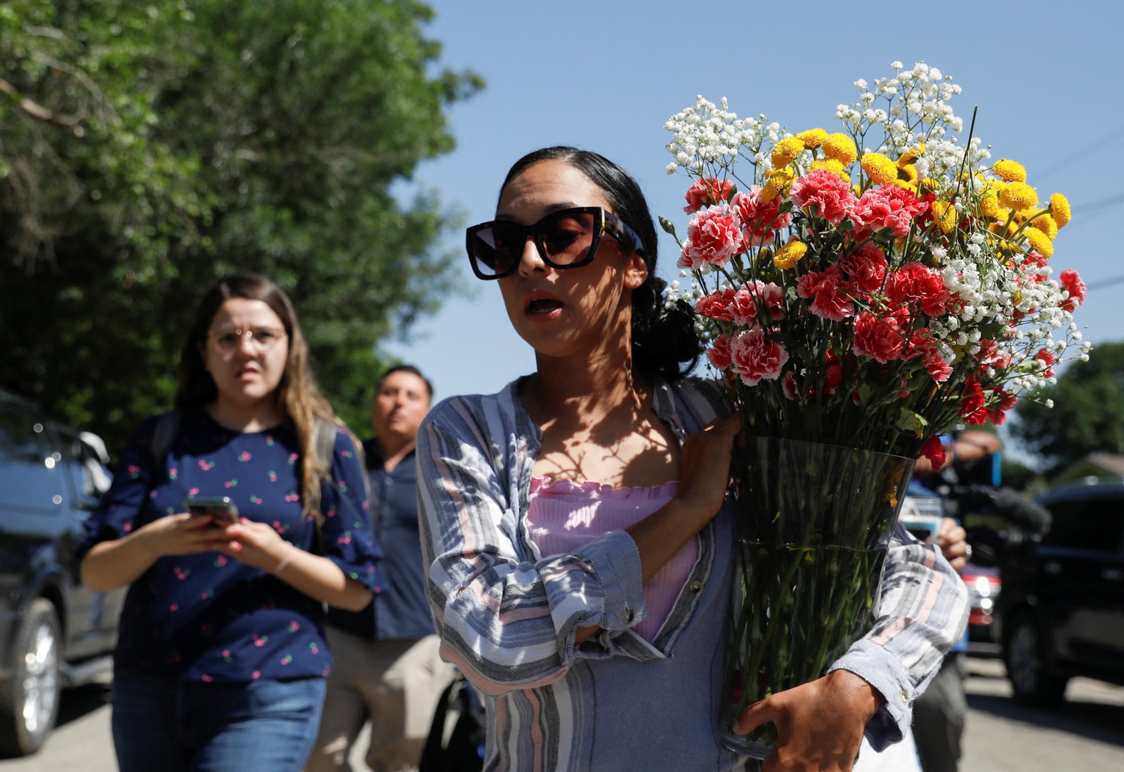 Leti Gomez chega à escola primária Robb com flores, um dia depois de um atirador matar 19 crianças e dois professores na escola em Uvalde, Texas, EUA — Foto: MARCO BELLO / REUTERS