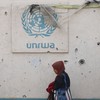 Mulher palestina em frente a prédio danificado da ONU em Gaza - Eyad BABA / AFP