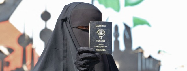 Mulher kuwaitiana exibe seu passaporte enquanto vota durante as eleições parlamentares na cidade do Kuwait. — Foto: Yasser Al-Zayyat / AFP