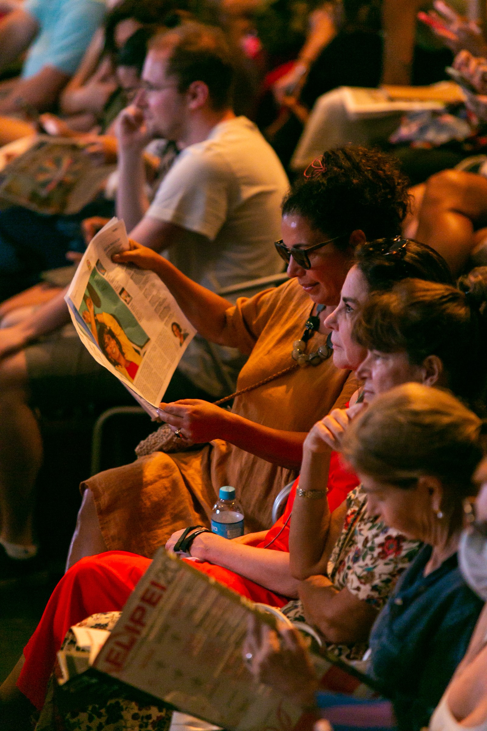 Público lendo o tabloide do GLOBO antes do início de uma das mesas do evento — Foto: Rebecca Alves / Agência O Globo
