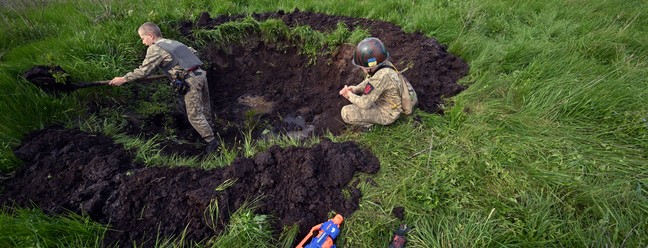 Crianças 'brincam' como se estivessem em trincheira da guerra na Ucrânia - Foto: Sergei Supinsky/AFP