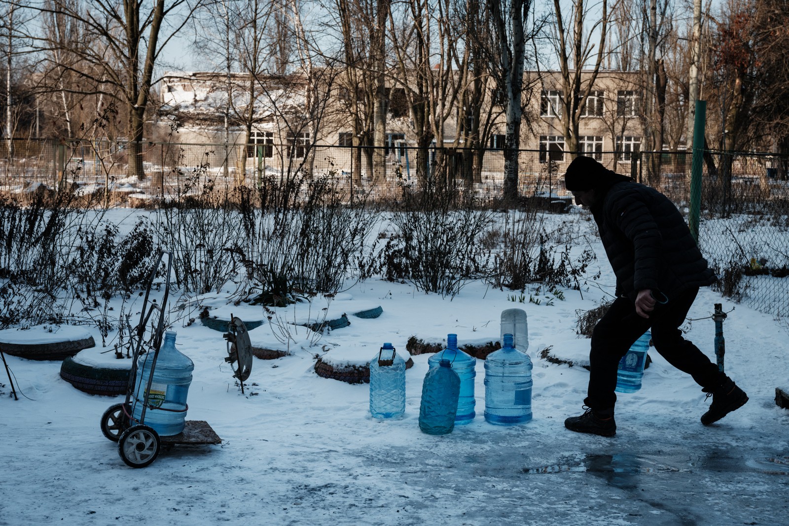 Andrej, de 51 anos, carrega galões de água depois de buscá-los em um ponto de fornecimento na cidade de Avdiivka, em meio à invasão russa da Ucrânia. — Foto: YASUYOSHI CHIBA / AFP - 08/02/2023