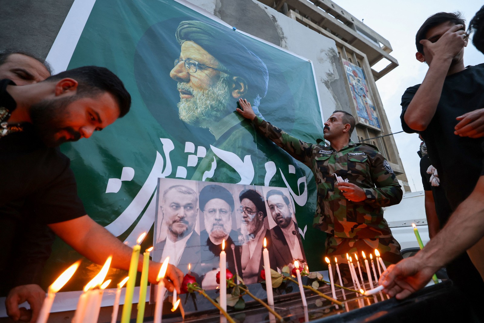 Iraquianos colocam flores e acendem velas para o falecido presidente do Irã, Ebrahim Raisi (foto), do lado de fora da embaixada iraniana em Bagdá — Foto: AHMAD AL-RUBAYE/AFP