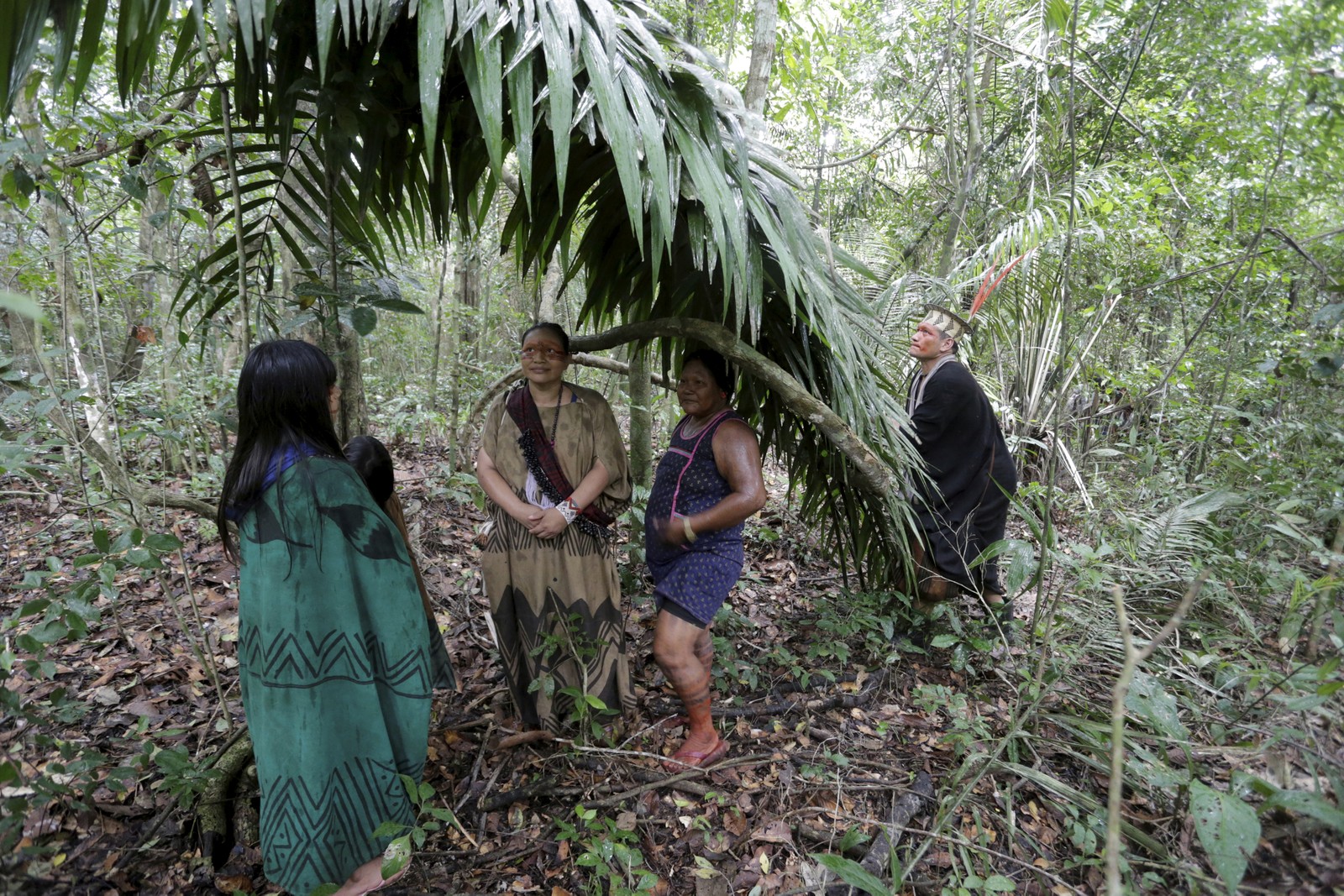 Ashanikas e kayapós tentam se proteger da chuva durante caminhada na floresta  — Foto: Domingos Peixoto / Agência O Globo