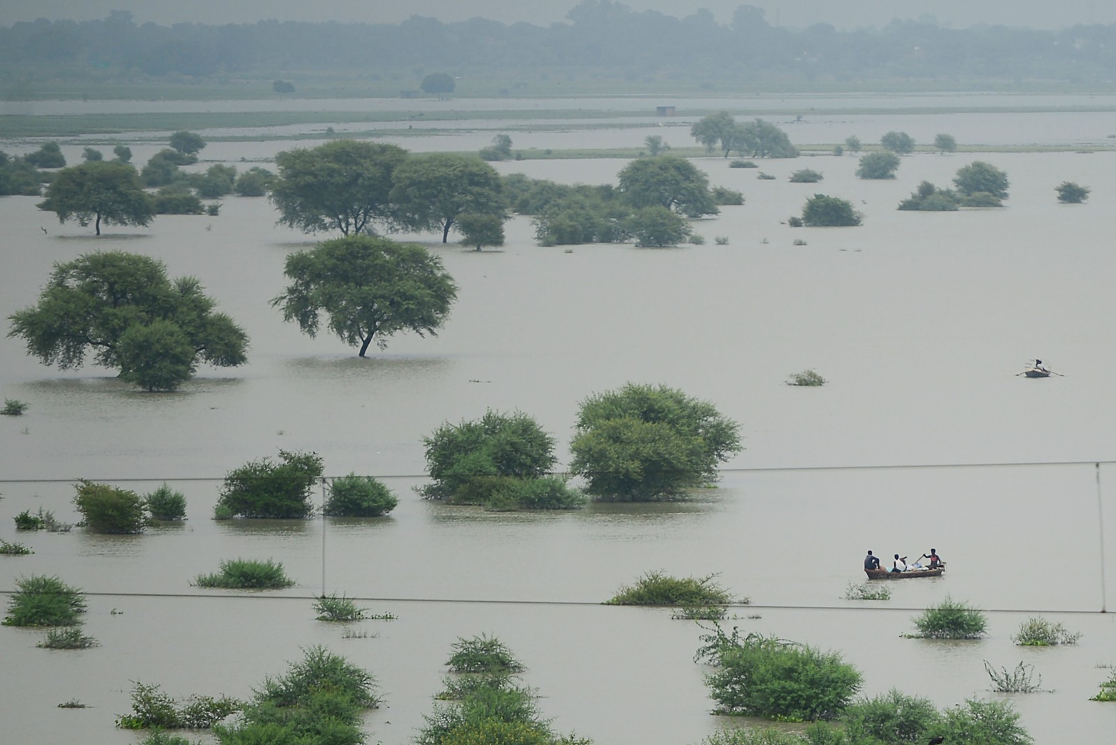 Moradores usam barcos para atravessar um rio Ganges inundado, à medida que os níveis de água nos rios Ganges e Yamuna aumentam, em Allahabad, Índia. Relatório do IPCC diz que chuvas de monção do verão indiano, uma fonte vital para regar as culturas destinadas a alimentar centenas de milhões de pessoas, enfraqueceram significativamente desde 1950, provavelmente devido ao aquecimento do Oceano Índico AFP 