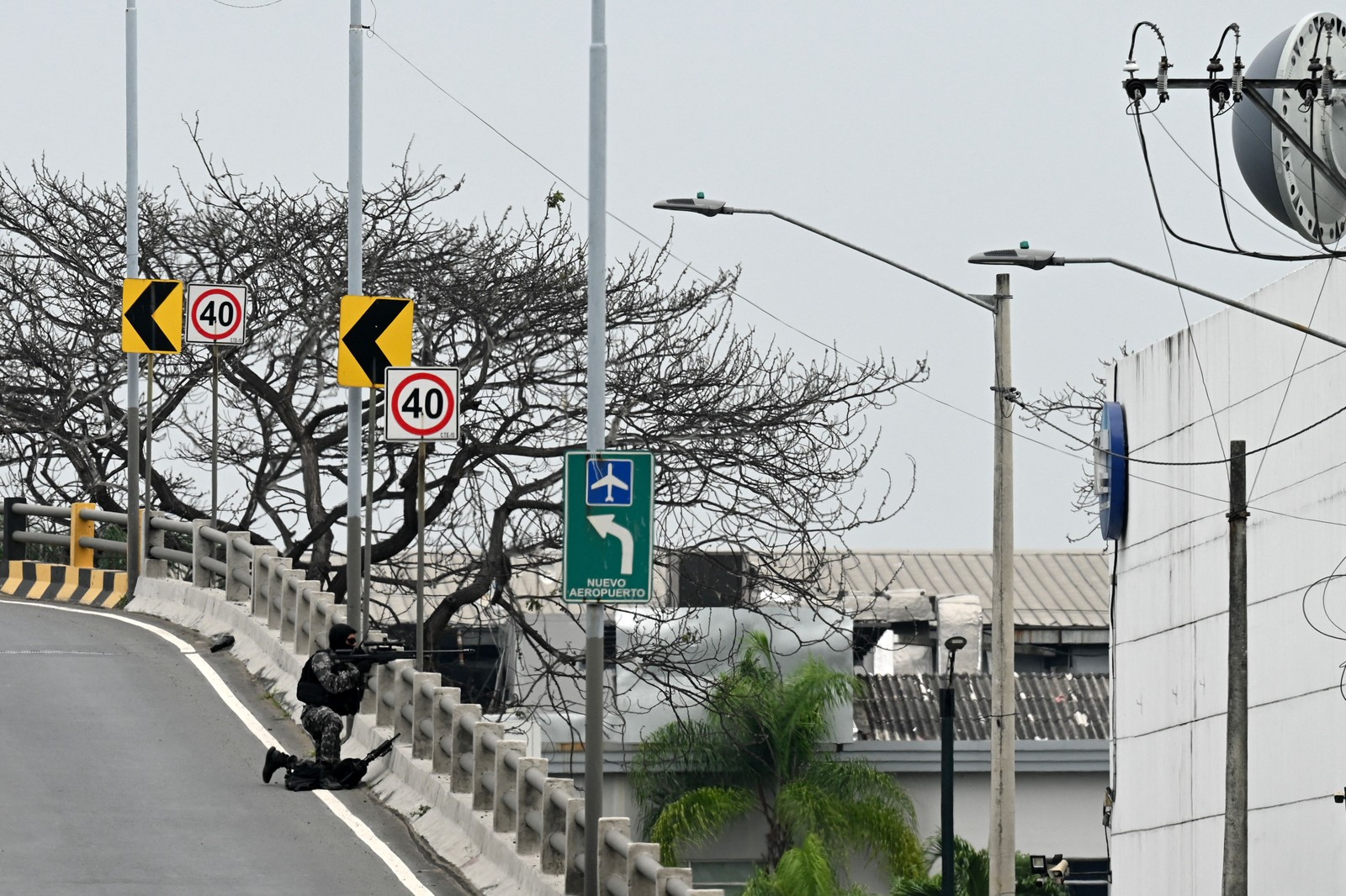 Franco-atirador equatoriano toma posição do lado de fora das instalações do canal de televisão equatoriano TC — Foto: MARCOS PIN / AFP