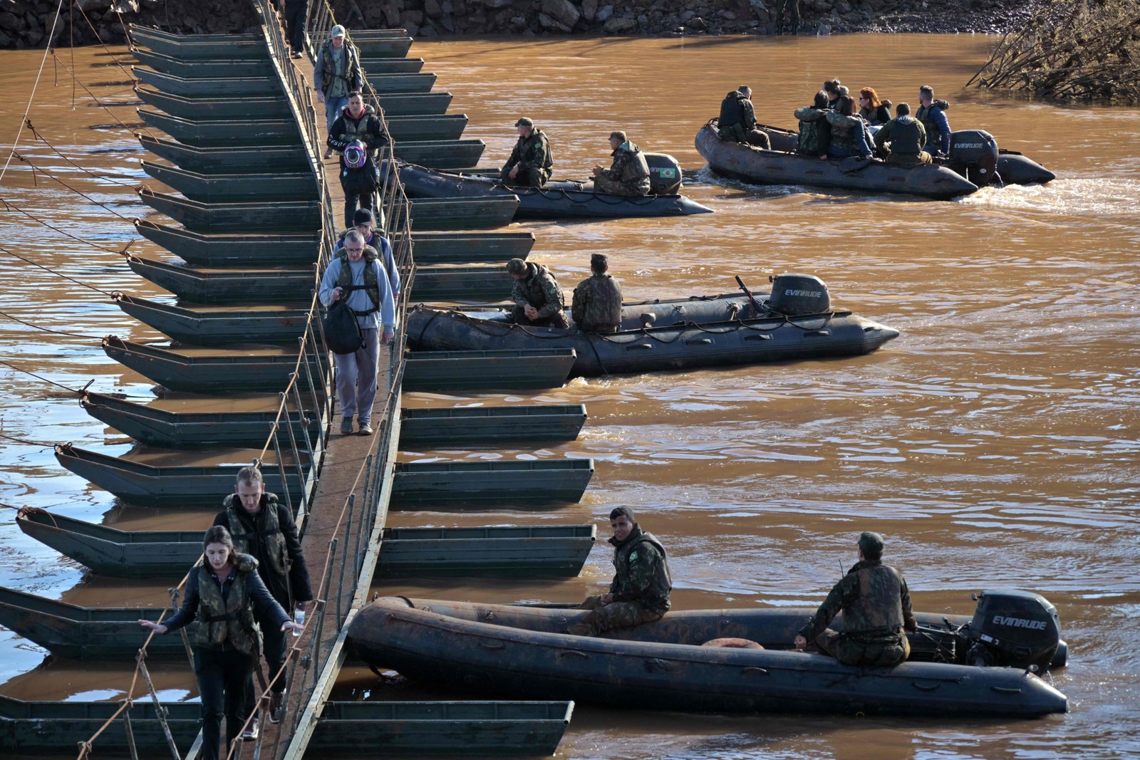 Militares ajudam pessoas na travessia de passarela de Arroio do Meio a Lajeado, sobre o rio Forquilha, desde que a ponte sobre o rio na Rodovia RS130 caiu durante as recentes enchentes, no Rio Grande do Sul — Foto: NELSON ALMEIDA / AFP