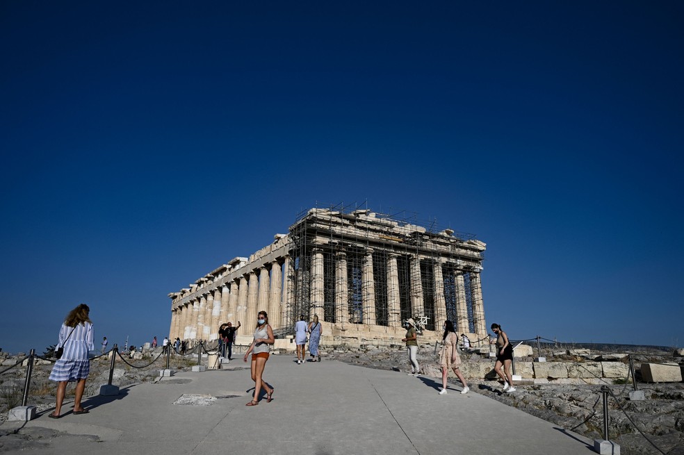 Turistas em frente às ruínas do Partenon, na Acrópole de Atenas, Grécia — Foto: Aris Messinis / AFP