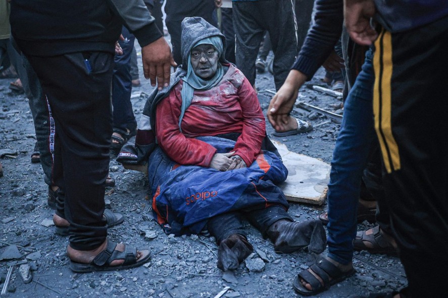 Mulher ferida senta em meio a destroços deixados por ataque de Israel em Rafah, no sul da Faixa de Gaza