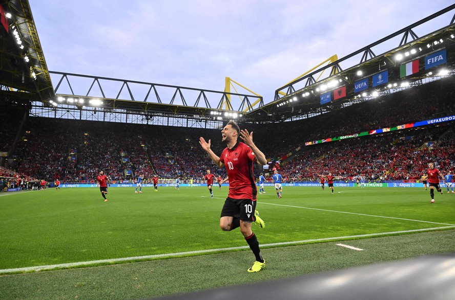 O meio-campista albanês nº 10, Nedim Bajrami, comemora o primeiro gol de seu time durante a partida de futebol do Grupo B da UEFA Euro 2024 entre Itália e Albânia, no BVB Stadion, em Dortmund