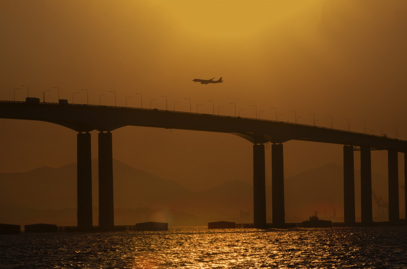Avião passa sobre a Ponte Rio- Niterói para pousar no Aeroporto Santos Dumont. — Foto: Marcos Ramos / Agência O Globo