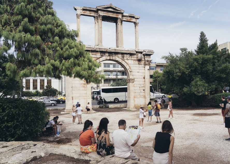 Turistas visitam o Arco de Adriano, em Atenas