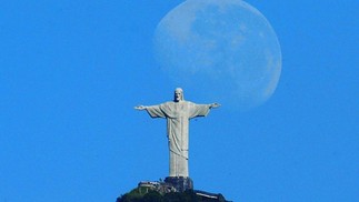 Lua nova é fotografada à luz do dia próxima ao Cristo  — Foto: Custódio Coimbra / Agência O Globo