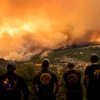 Bombeiros observam o fogo se alastrar por uma área de florestas no condado de Butte - Josh Edelson/AFP