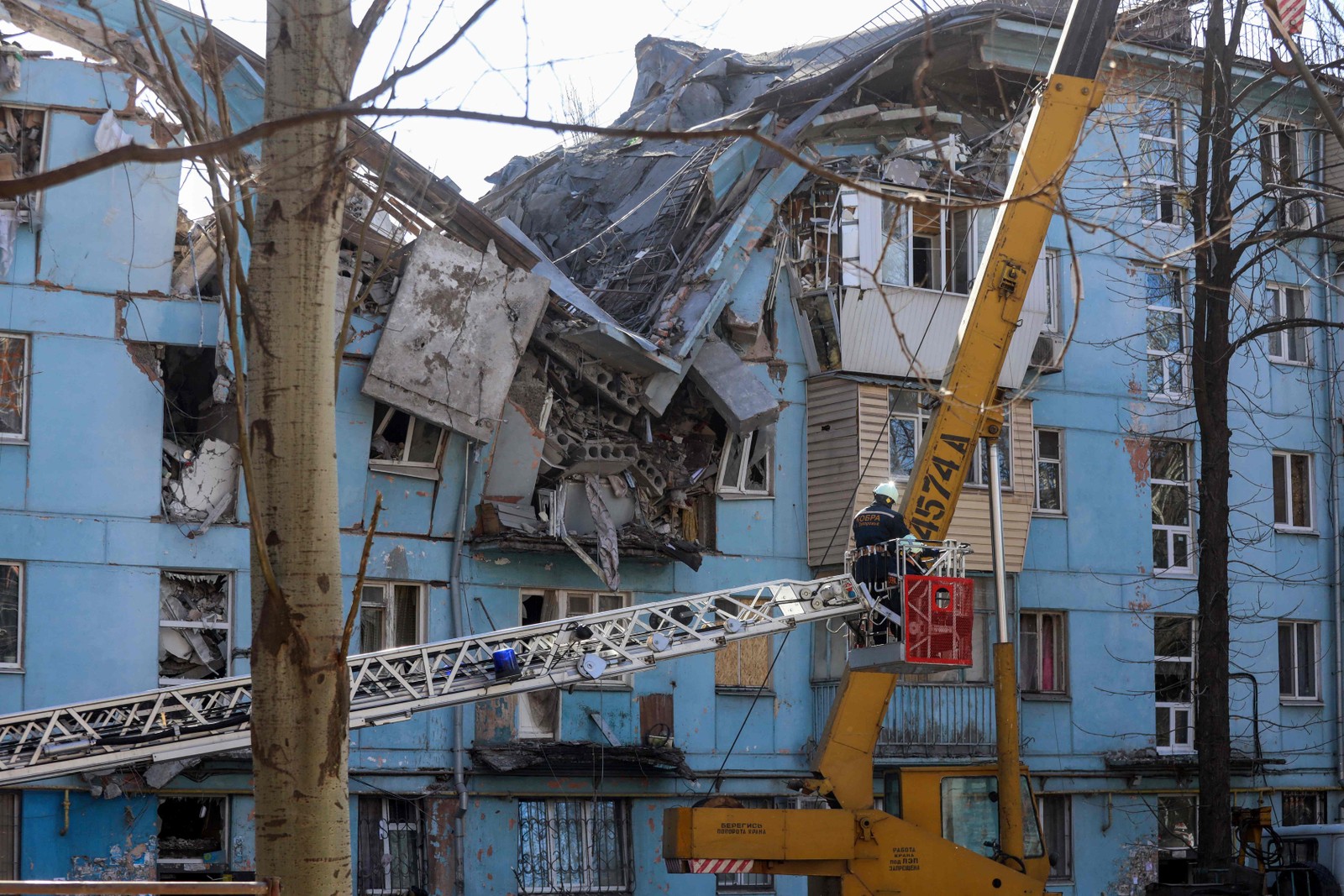 Equipes de resgate ucranianas em uma escada rolante trabalham em um prédio residencial de cinco andares destruído após um ataque com mísseis em Zaporizhzhia — Foto: KATERINA KLOCHKO/AFP