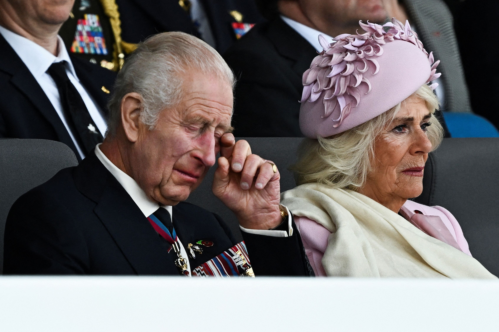 Rei Charles, ao lado da rainha Camilla, da Grã-Bretanha, reage ao participar de um evento comemorativo nacional do Reino Unido para marcar as comemorações do 80º aniversário do Dia D — Foto: Dylan Martinez / POOL / AFP