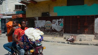 Moradores deixam suas casas enquanto a violência das gangues aumenta em Porto Príncipe, Haiti, e passam pelo corpo de uma vítima. — Foto: Clarens SIFFROY / AFP