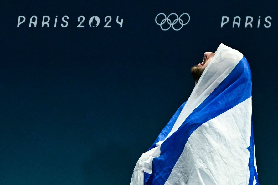 Artem Dolgopyat, medalhista de prata na ginástica, celebra seu resultado com a bandeira de Israel, na Bercy Arena