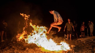 Homem salta uma fogueira durante as celebrações anuais de São João em uma praia em Alicante, Valência, Espanha — Foto: JOSE JORDAN / AFP