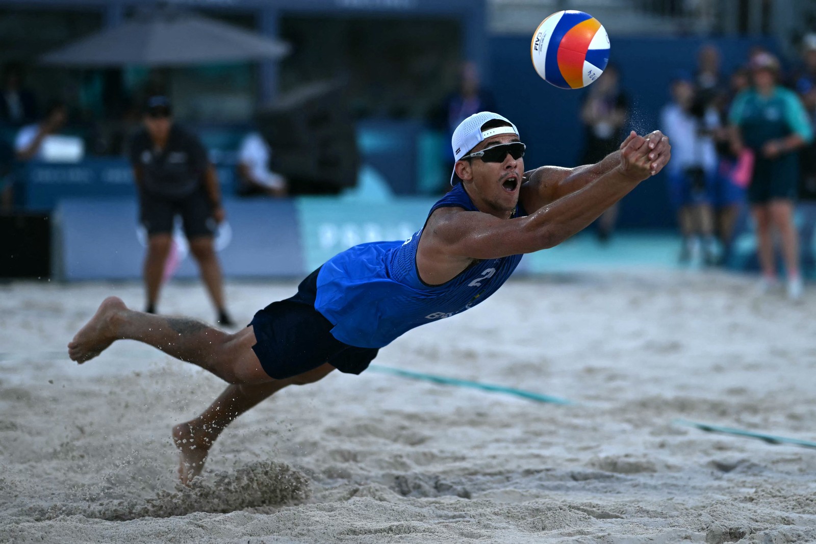 Arthur Diego Mariano Lanci, mergulha para devolver a bola na partida de vôlei de praia masculina da categoria E entre Brasil e Áustria durante os Jogos Olímpicos de Paris 2024, no Estádio da Torre Eiffel, em Paris, em 28 de julho de 2024. (Foto de ) — Foto: Mauro PIMENTEL / AFP