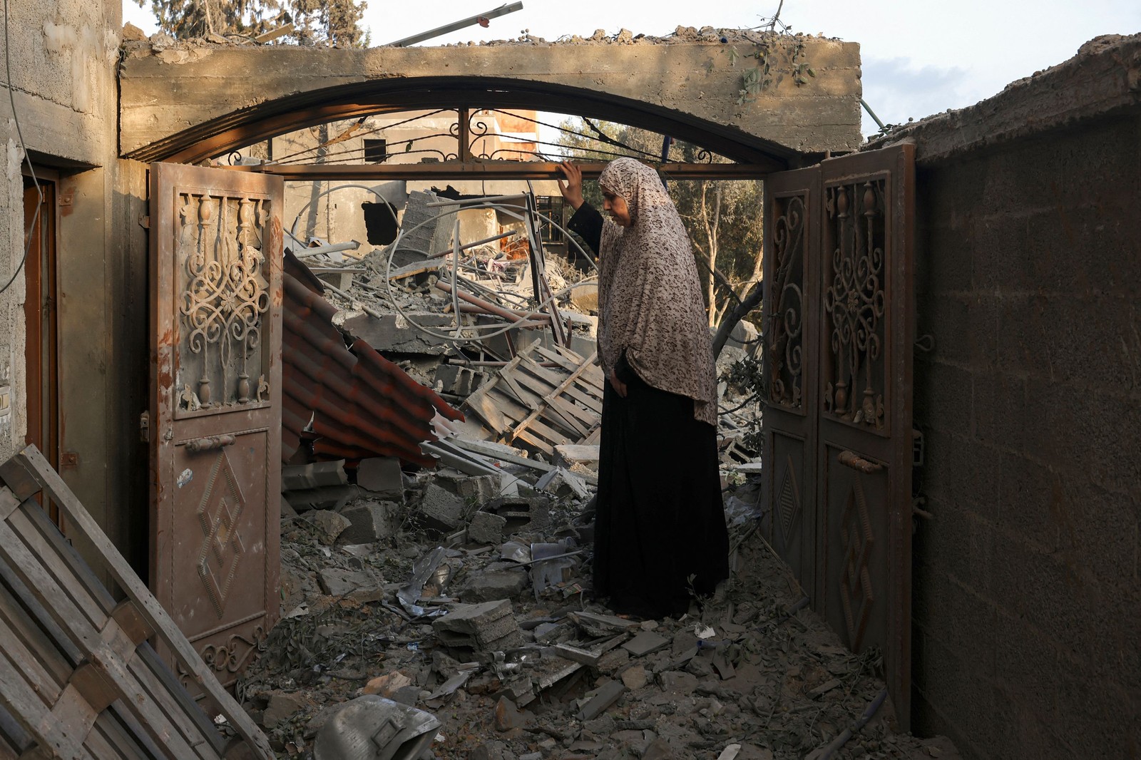 Mulher inspeciona danos em sua casa causados por bombardeios israelenses, em Gaza — Foto: MOHAMMED ABED / AFP