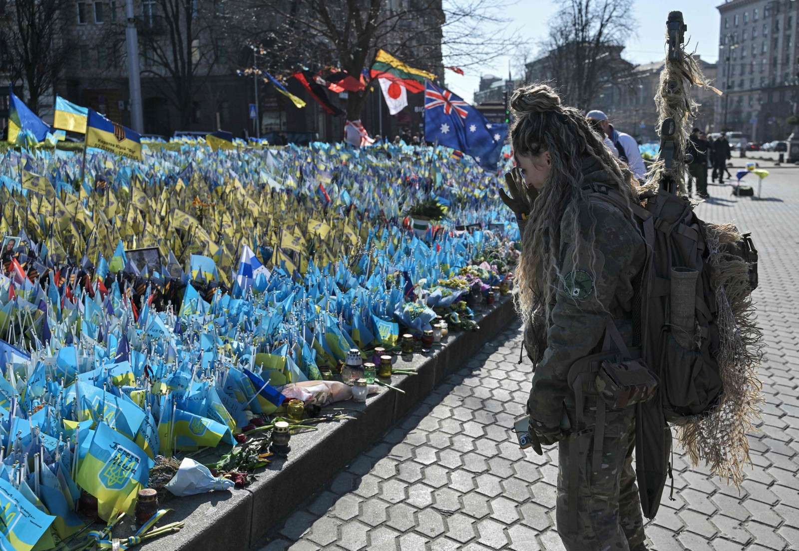 Em Kyiv, na Ucrânia, uma militar observa o memorial em homenagem aos soldados mortos no conflito — Foto: GENYA SAVILOV