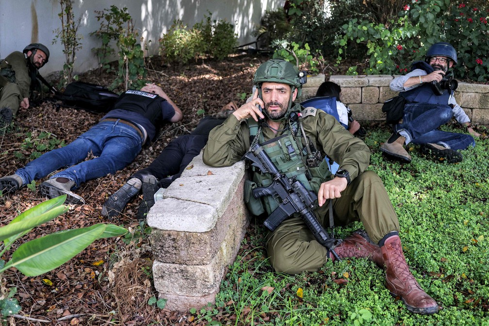 Jornalistas se protegem durante um alerta para um ataque de foguete na cidade de Sderot, no sul de Israel, perto da fronteira com Gaza — Foto: Menahem KAHANA / AFP