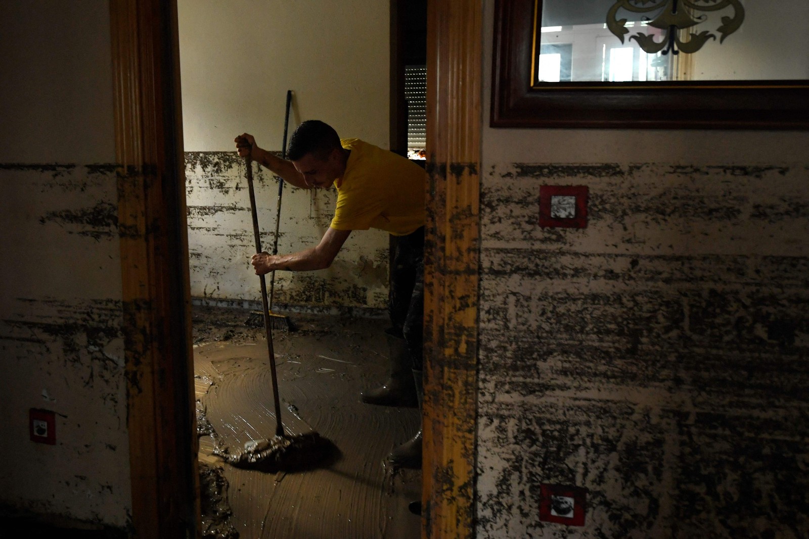 Um morador limpa lama em sua casa na cidade de Villamanta. tempestade do fim de semana afetou quase todo o país, com as chuvas mais fortes registradas ontem nas províncias costeiras de Cádiz, Tarragona e Castello — Foto: Oscar DEL POZO CAÑAS / AFP