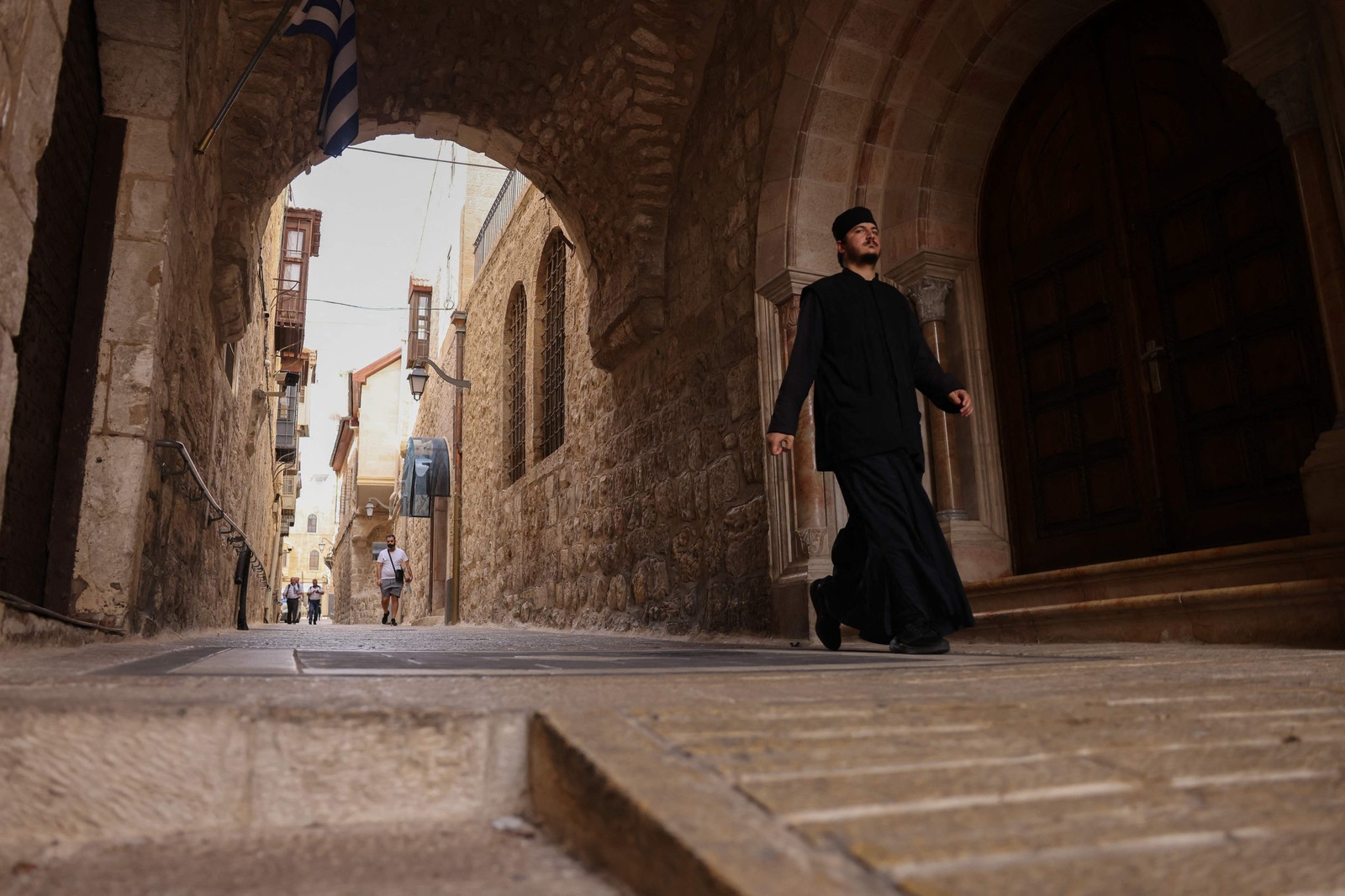 Monge caminha em beco da antiga Jerusalém; clima entre judeus e muçulmanos na cidade é de desconfiança — Foto: Ahmad Gharabli/AFP