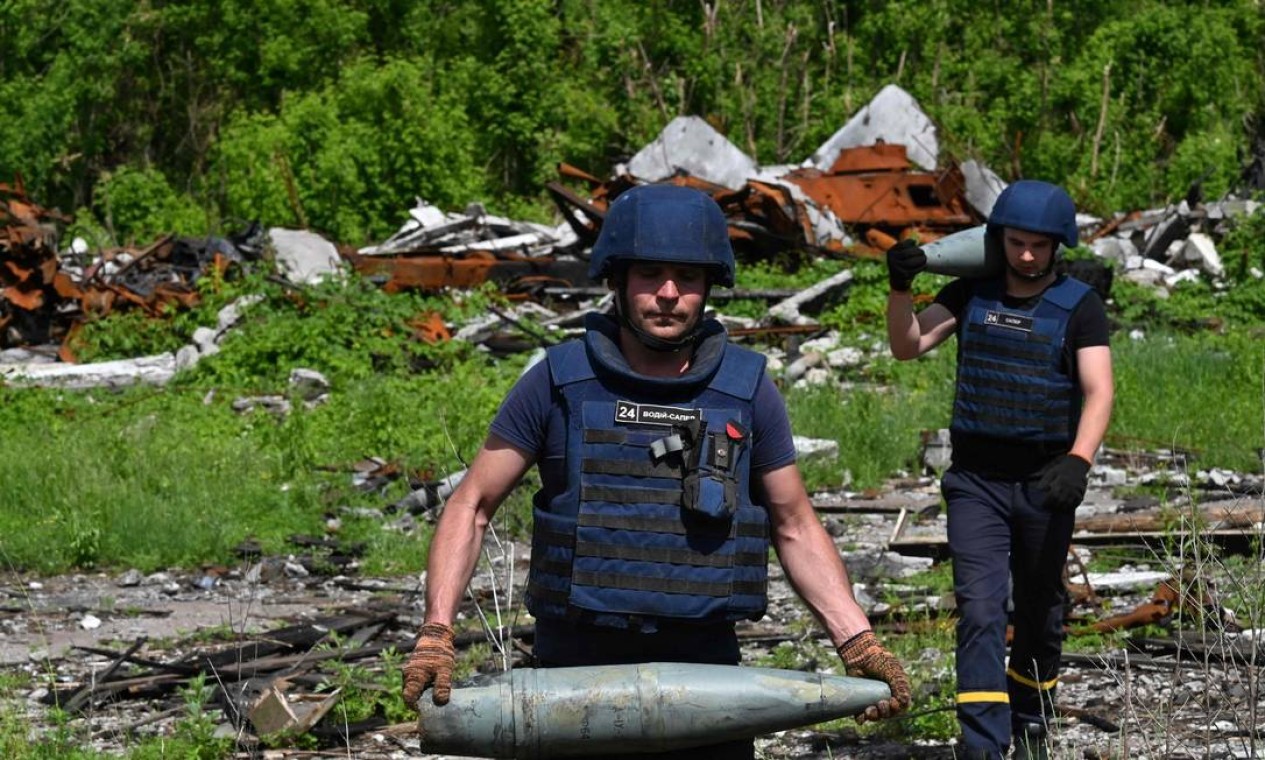 Militares especializados removem explosivos na vila de Yahidne, nos territórios libertados da região de Chernihiv, Ucrânia — Foto: SERGEI SUPINSKY / AFP