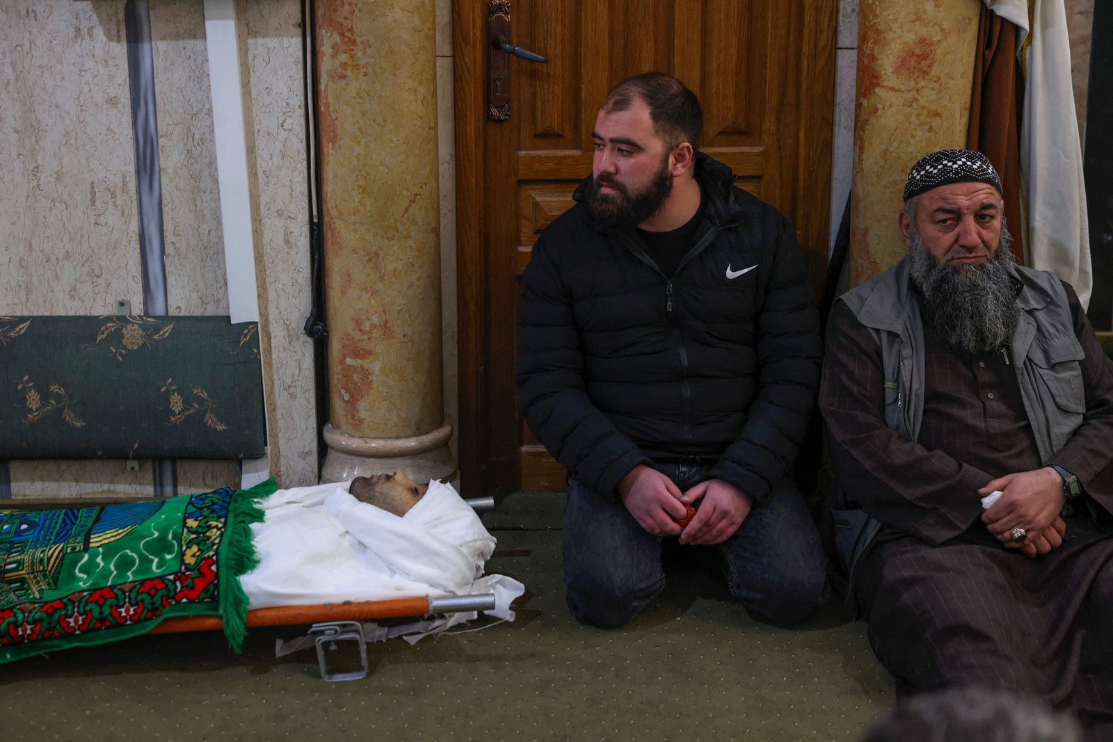 Palestinos rezam ao lado do corpo de Nassim Abu Fouda, morto pelas forças de segurança israelenses, em Hebron, na Cisjordânia — Foto: HAZEM BADER/AFP