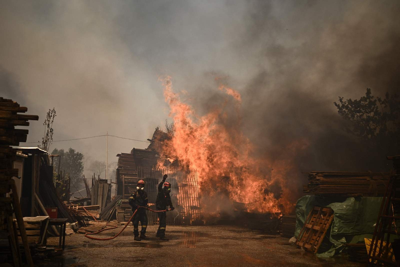 Bombeiros combatem um incêndio florestal em Chasia, nos arredores de Atenas — Foto: Angelos Tzortzinis/AFP