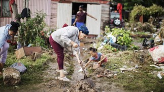 Moradores limpam as águas das enchentes de suas casas. As enchentes causadas por chuvas torrenciais e ventos fortes na costa leste da África do Sul mataram pelo menos 22 pessoas, disseram as autoridades locais na terça-feira. As inundações atingiram vários locais em duas províncias do leste, dois raros tornados foram detectados, as temperaturas caíram e a neve caiu em algumas regiões centrais. — Foto: GIANLUIGI GUERCIA/AFP