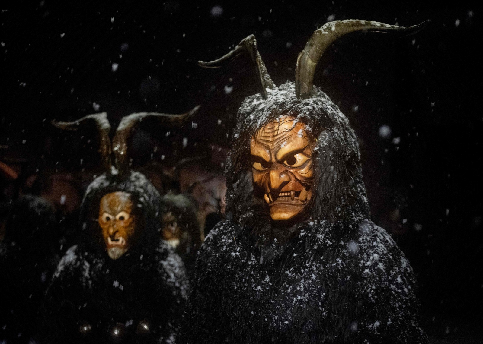 Pessoas vestindo máscaras de diabo e pele de carneiro negra representando Krampus, o ajudante de São Nicolau, participam do desfile de São Nicolau (Nikolospiel) em Bad Mitterndorf, Estíria, Áustria — Foto: JOE KLAMAR/AFP