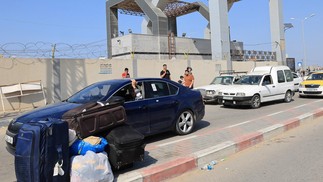 Palestinos com passaportes estrangeiros chegam à passagem de Rafah, entre a Faixa de Gaza e o Egito — Foto: Said Khatib/AFP