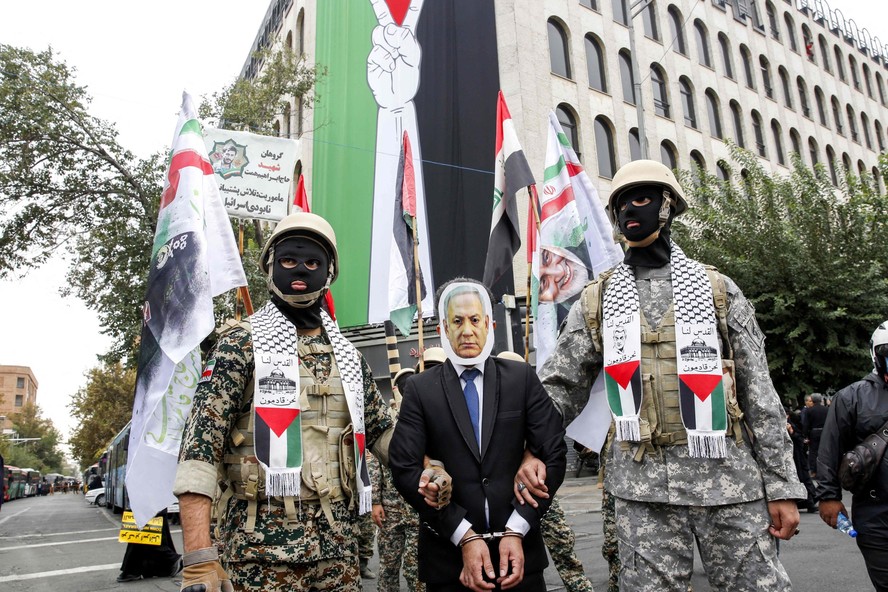 Membros das forças iranianas de Basij simulam prisão de homem com máscara do rosto do primeiro-ministro de Israel, Benjamin Netanyahu, durante protesto pró-palestinos em Teerã