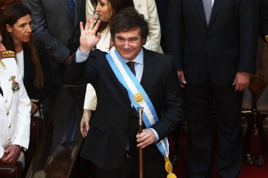 Javier Milei acena depois de receber a faixa e o bastão presidencial durante sua cerimônia de posse no Congresso em Buenos Aires