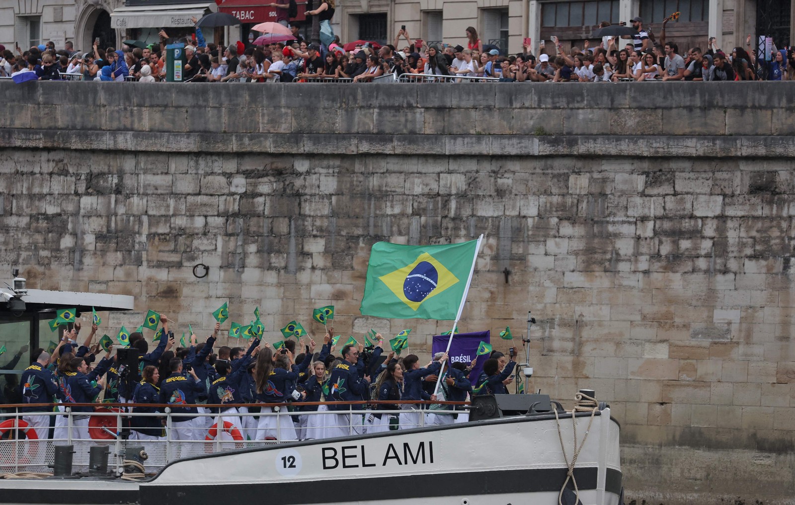 Espectadores aplaudem a delegação brasileira que desfila pelo Rio Sena durante a cerimônia de abertura da Olimpíada de Paris — Foto: Thomas SAMSON / AFP