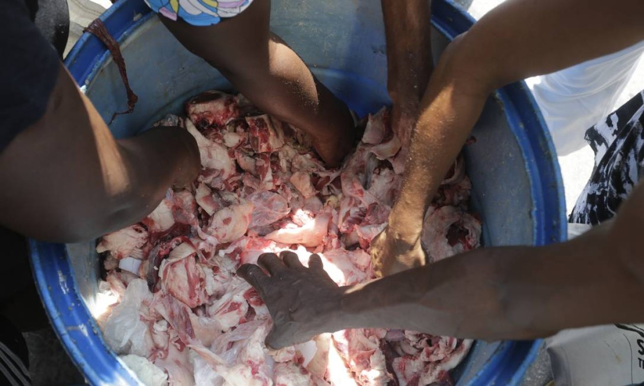 Diante do desemprego e da inflação galopante, pelanca vira esperança de alimento para famílias que buscam com o que matar a fome. — Foto: Domingos Peixoto / Agência O Globo