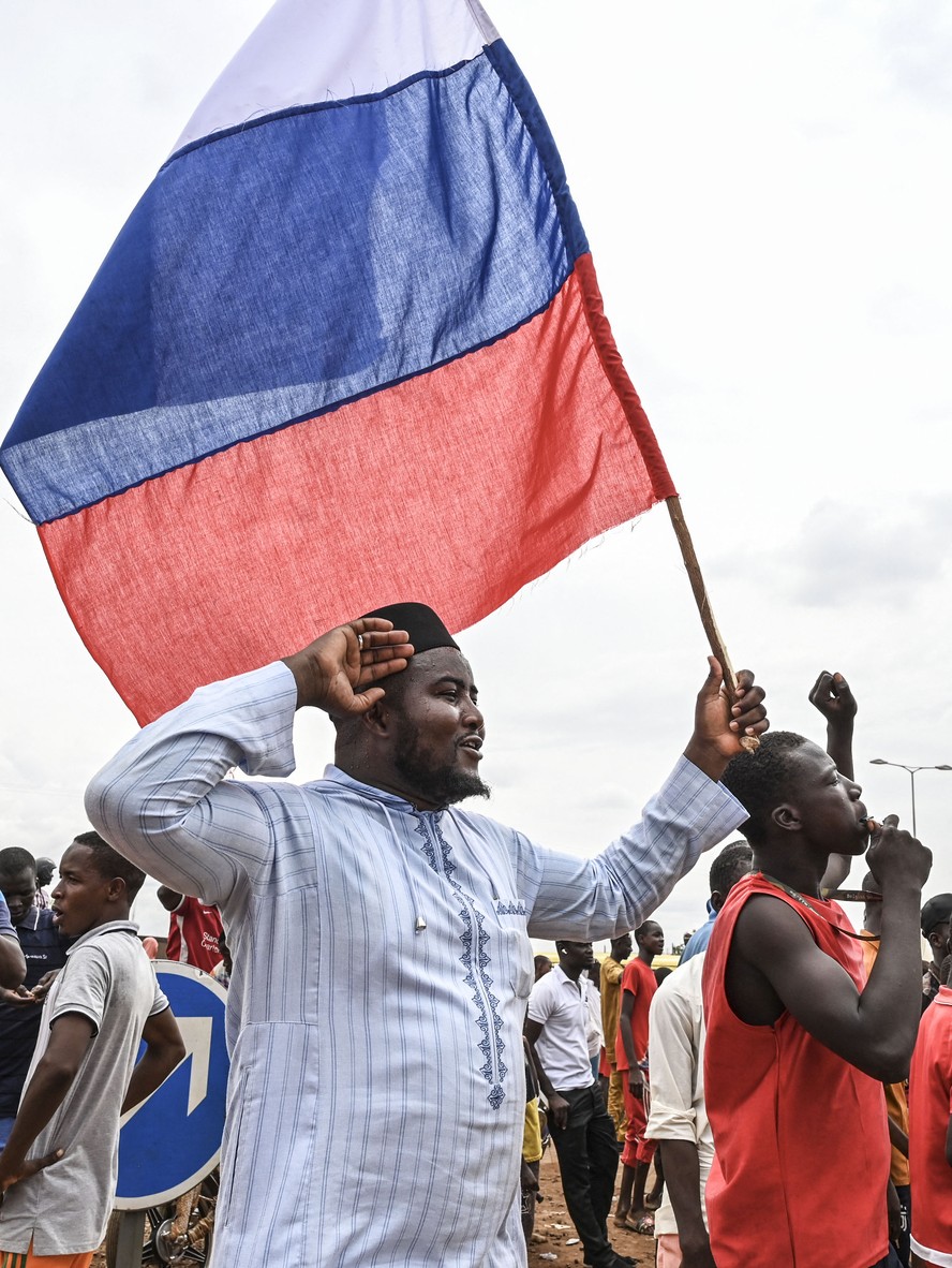 Apoiadores do governo golpista do Níger carregam bandeiras da Rússia em manifestação em frente à base militar francesa em Niamei