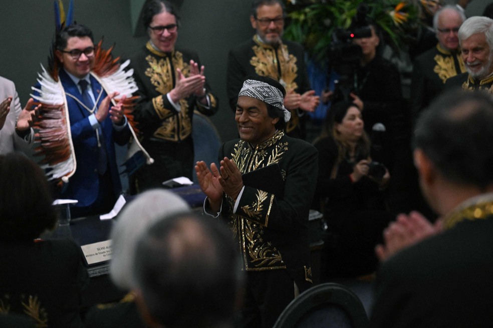 Ailton Krenak na noite de sua posse na ABL, ao fundo Luiz Eloy Terena, advogado e representante do Ministério dos Povos Indígenas — Foto: AFP